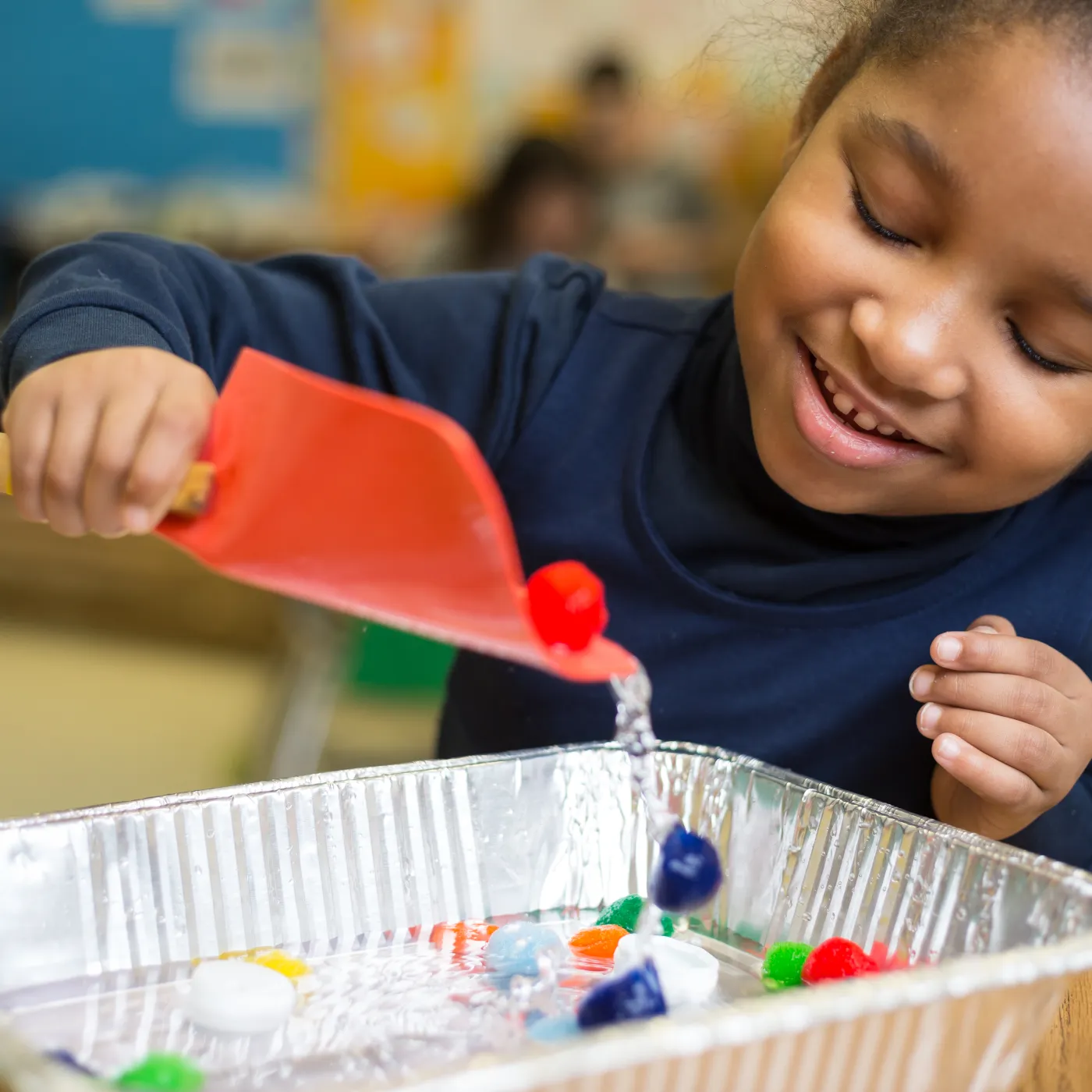 Girl using a scoop to gather trash.